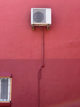 Air Conditioning Unit On Pink Building Wall