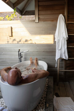 Man soaking in an outdoor bath on vacation
