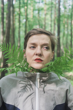 Woman with green leaves in forest during daytime in summer