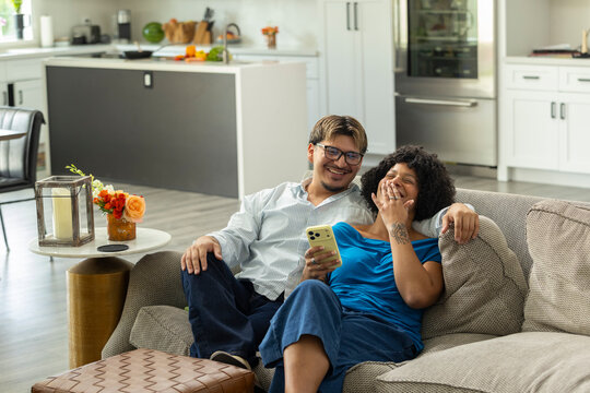 Young Couple laugh at home with Cell phone 