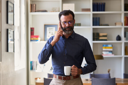 BusinessMan Talking on Phone While Holding a Cup