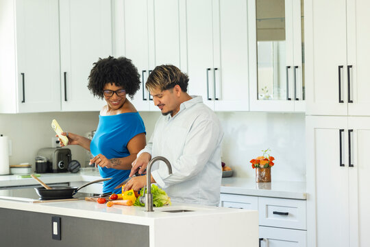 Young couple chat  in Kitchen prepare meal with smartphone 