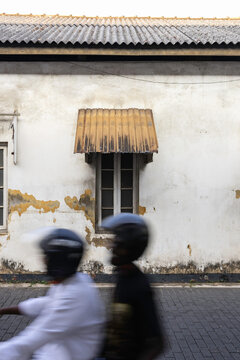A couple on a motorbike flying past creating motion blur