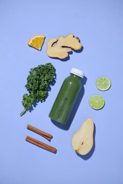 Green smoothie ingredients artfully arranged on a blue