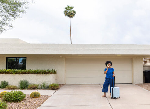 Black woman  outdoors wait  rideshare talking  cell phone 