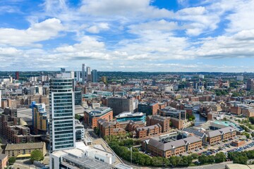 Fototapeta premium Panoramic aerial view of Leeds city centre featuring Bridgewater Place Leeds Dock modern office buildings historic warehouses and the city skyline beneath a bright summer sky with scattered clouds