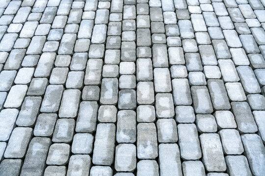 Top view of fresh sidewalk pavers creating orderly stone surface. Street renovation, pedestrian area improvement and hardscape design concept.