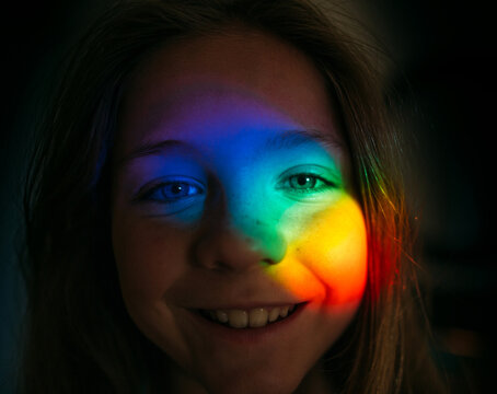 Portrait of a girl with a rainbow on her face