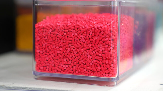 Close up of bright pink plastic masterbatch pellets