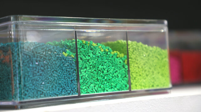 Green plastic polymer granules stored in transparent compartments