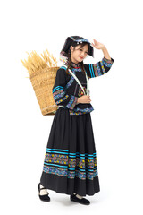 Obraz premium Young woman in traditional ethnic dress carrying a woven basket of wheat