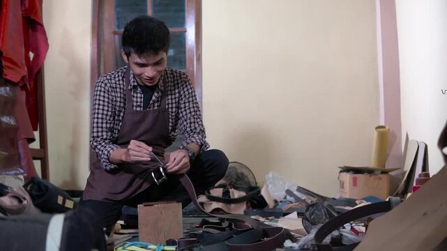 A focused scene shows a man seated on a cluttered workshop floor, repairing shoes with tools and scraps of leather nearby; warm indoor lighting captures hands