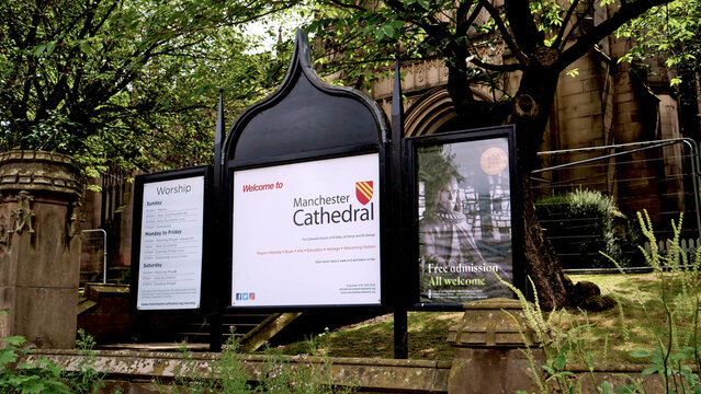 Manchester, England, UK - 18 June 2026: Manchester Cathedral welcome signboard with service times, historic UK church information board on street, religion and tourism in England