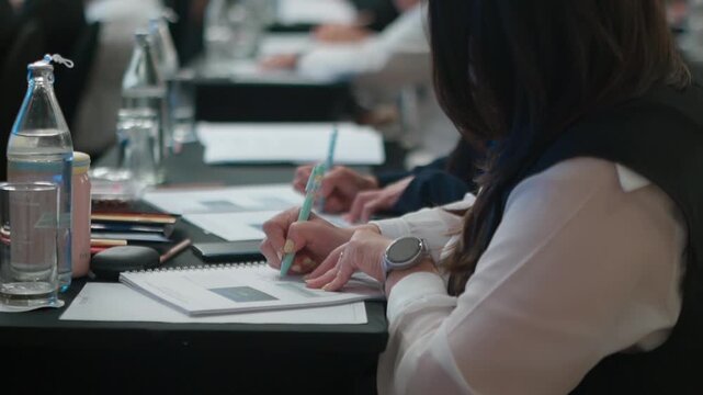 Businesswoman Taking Notes During Corporate Seminar