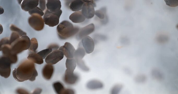 Coffee beans falling through the air in dramatic super slow motion