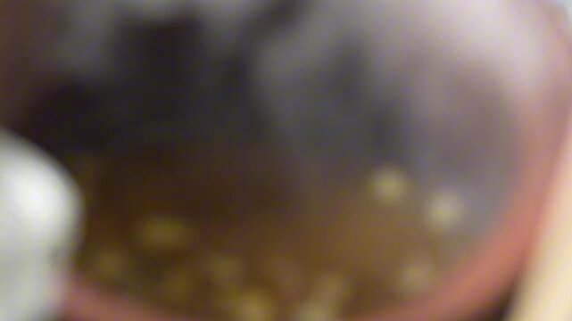 Close-up of traditional beef soto boiling in a large pot, with steam, broth, potatoes and ladles, ideal for culinary footage, street food and cooking.