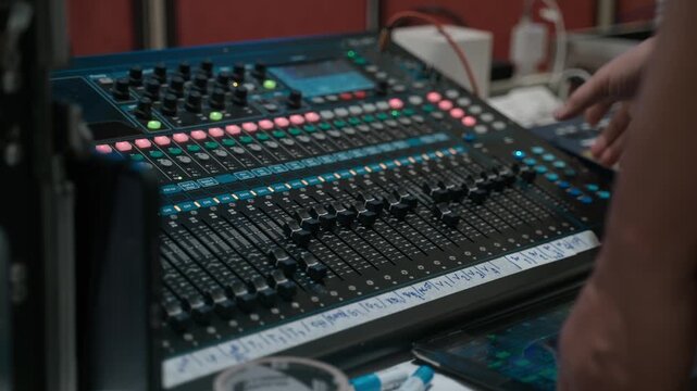 Sound Engineer Adjusting Audio Mixing Console During Live Event