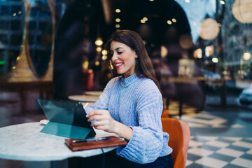 Fototapeta premium Radiant woman laughing during remote work with digital tablet in urban cafe, positive mindset, successful startup project, high speed 5G connection, mobile technology for business, authentic people