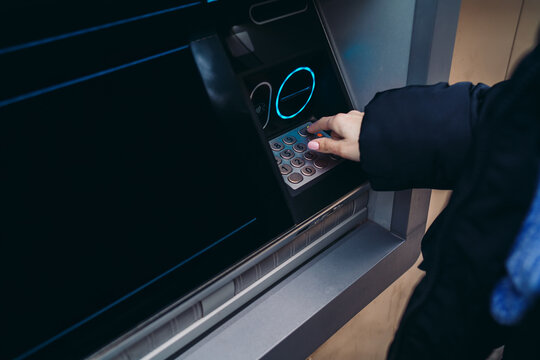 Close up of hand entering pin code on ATM keyboard, secure financial transaction, withdrawing money from cash machine, banking security, electronic payment service on city street