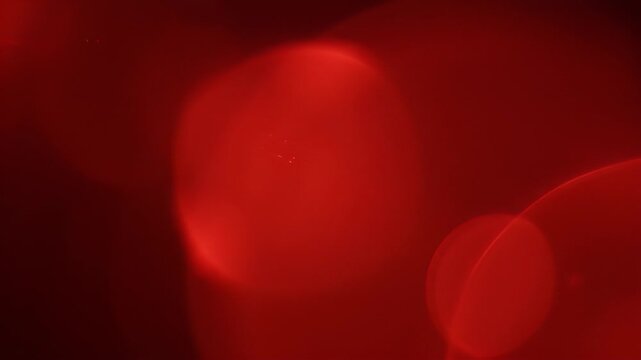 Abstract glowing red and black background with bokeh effect.
