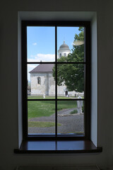 Fototapeta premium View from the museum window to the Church of the Assumption of the Blessed Virgin Mary in Krylos, Ivano-Frankivsk region, Ukraine