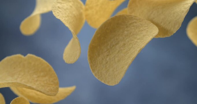 Potato chips falling in slow motion 1000 fps against blue background