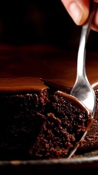 Cinematic View Of Fork Cutting Into Dense Chocolate Mud Cake With Fudge Like Texture And Rich Ganache Topping In Dark Moody Lighting Intense Chocolate Lover Dessert Commercial