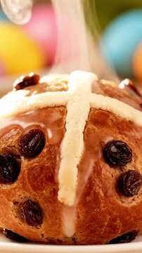 Glossy Glazed Hot Cross Bun In Closeup With White Cross Detail Raisins Inside And Steam Rising Ready To Serve