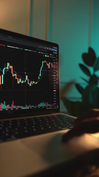 Trader Analyzing Stock Market Charts on a laptop through a brokerage platform.