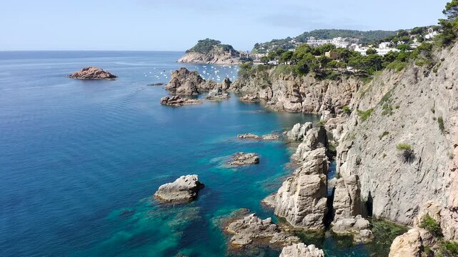 Aerial view of the rugged cliffs surrounding Tossa de Mar, where rocky reefs, hidden coves and crystal-clear Mediterranean waters create a spectacular coastal landscape. 