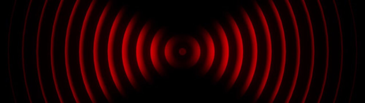 Abstract circular sound waves expanding from center in glowing red circles radio signal frequency vibration circles radio signal frequency vibration