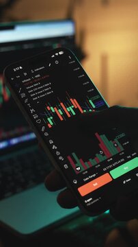 Trader Analyzing Stock Market Charts on Smartphone Through Brokerage App