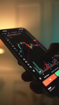 Trader Analyzing Stock Market Charts on Smartphone Through Brokerage App