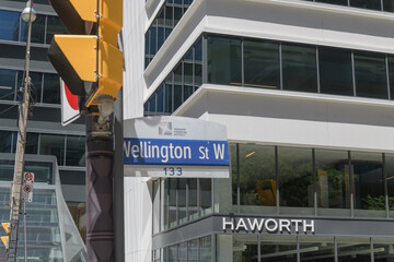 Naklejka premium exterior building facade and sign of Haworth, an office furniture store, and defocused street sign, at 55 University Av, Toronto