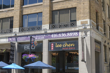 Naklejka premium exterior building facade with signs including that of Lee Chen Asian Bistro, a Chinese restaurant, located at 214 King St W, Toronto