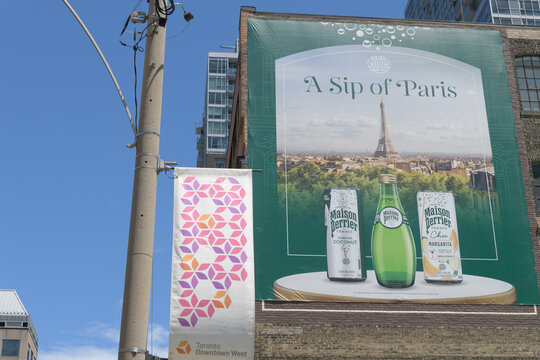 'A Sip of Paris' OOH advertising banner for sparkling mineral water brand Perrier on the west facing wall of 225 Richmond St W, Toronto