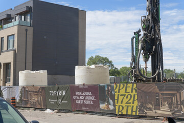 Naklejka premium development at 72 Perth Avenue, with advertising promotional hoarding banners and heavy machinery in Toronto (Castlepoint Numa + Hazelview)