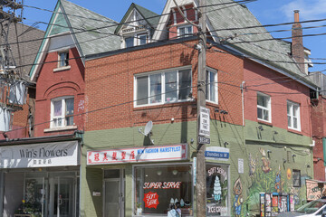Naklejka premium Win's Flowers and Super Serve signs on Dundas St W near Kensington Av, Toronto
