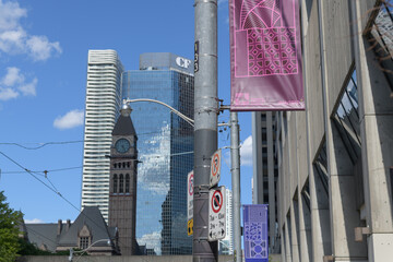 Naklejka premium pole mounted Financial District banners on Queen St W opposite City Hall with view of clock tower, CF headquarters and Massey condo, Toronto
