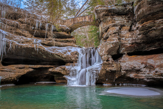 Frozen waterfall with a bridge over it at the beginning of Old Man's Cave trail in Hocking Hills State Park in Ohio.