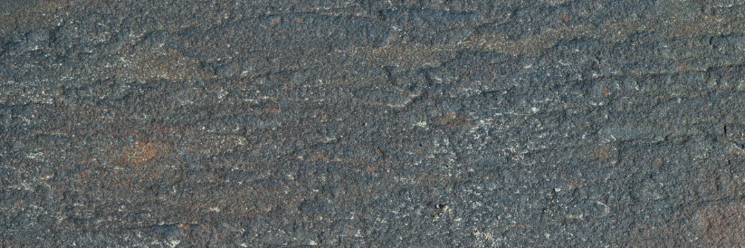 Stone texture. Minimalist dark grey basalt rock surface texture with fine grain structure.