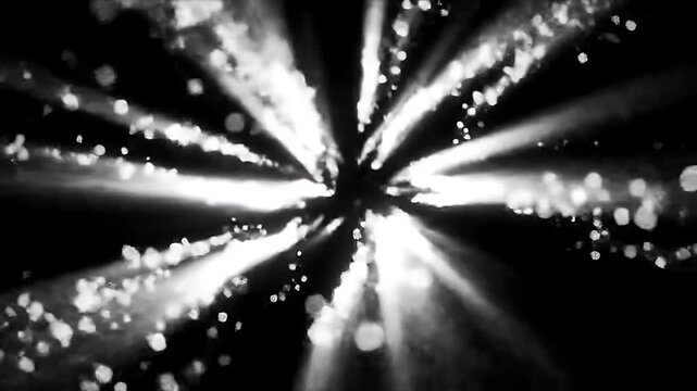 Abstract bursts of light and particles radiating from a central source in monochrome.
