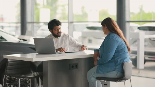 Indian car salesman giving car keys to female customer
