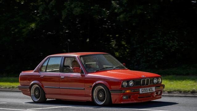 Milton Keynes,Bucks,UK - June 18th 2026: 1990 red BMW e30 classic car driving on a British road