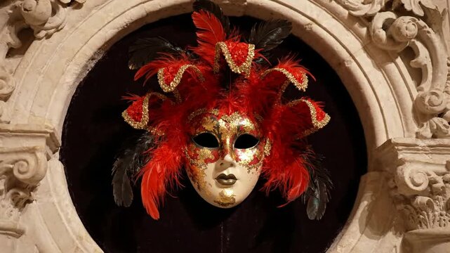 Venetian carnival mask with red feathers and gold details in ornate stone archway venetian mask masquerade