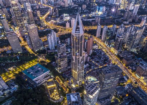 Aerial view of the JW Marriott Hotel Shanghai at Tomorrow Square surrounded by illuminated skyscrapers, dense urban infrastructure, and glowing streets in Shanghai, Shanghai, China.
