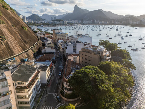Aerial view of Urca neighborhood with its characteristic steep hillside, urban buildings, and boats anchored in Guanabara Bay in Rio de Janeiro, Rio de Janeiro, Brazil.