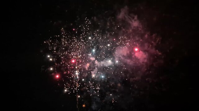 Spectacular fireworks exploding and bursting in the night sky during a celebration creating a colorful and dazzling display of lights for a festive holiday event