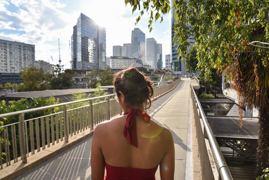 Woman in Red Dress Walking along Modern Office Buildings at La Defense District in Paris, France