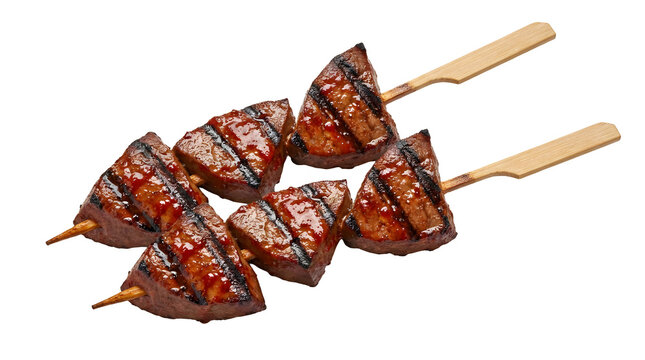 Grilled Peruvian anticuchos beef heart meat skewers with glaze and dark char grill marks